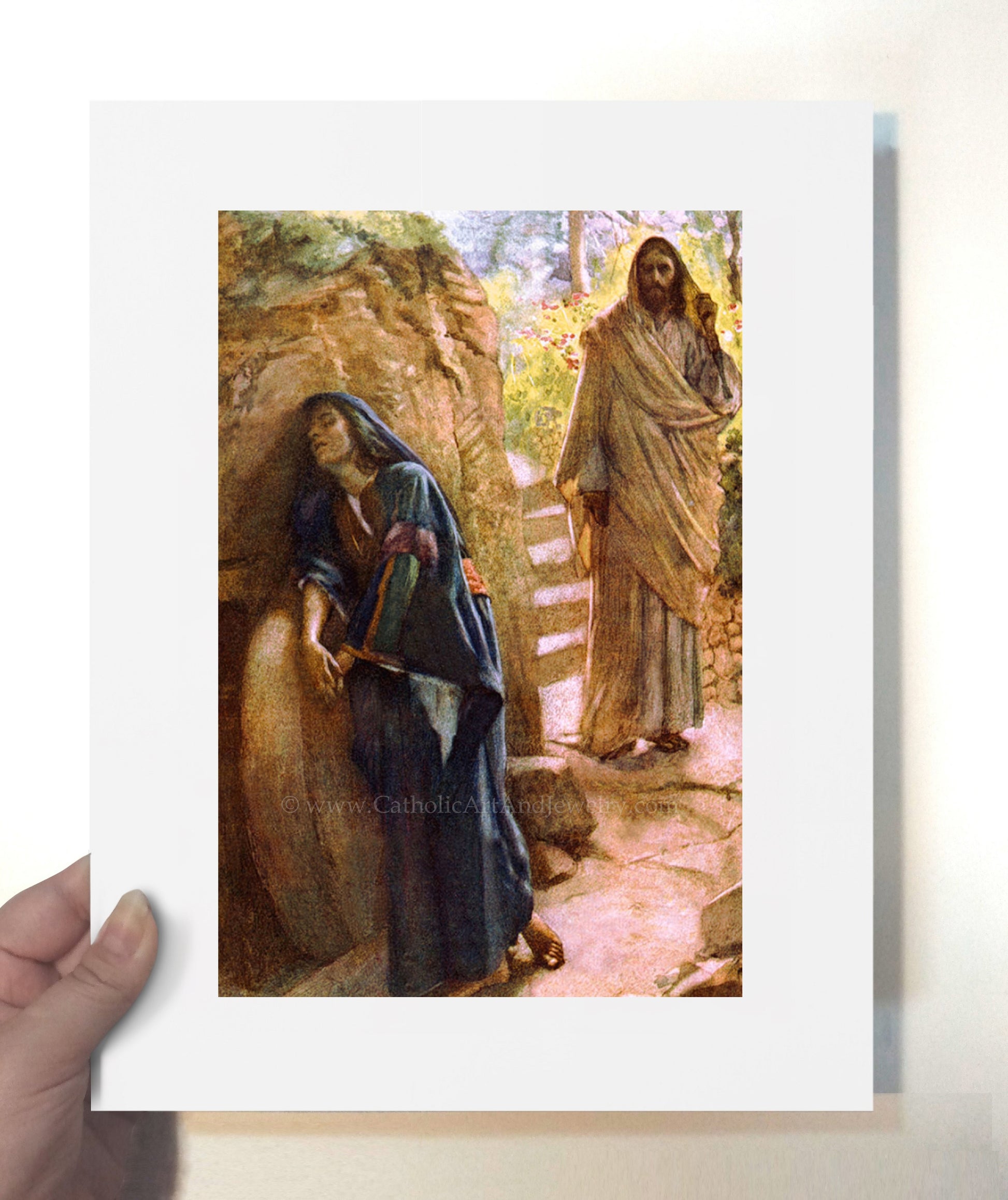 a hand holding a card with a painting of jesus and mary