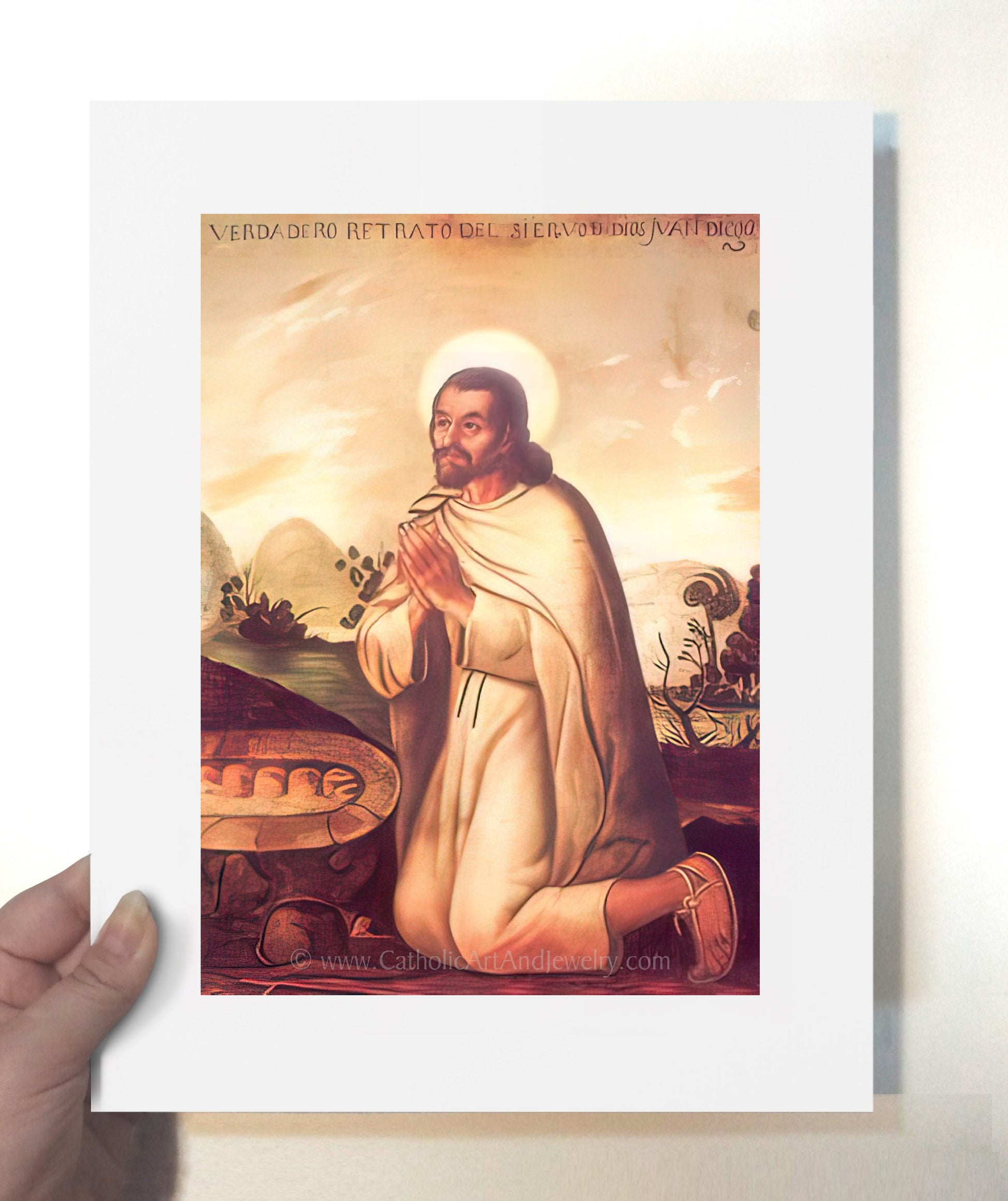 a hand holding a card with a painting of jesus