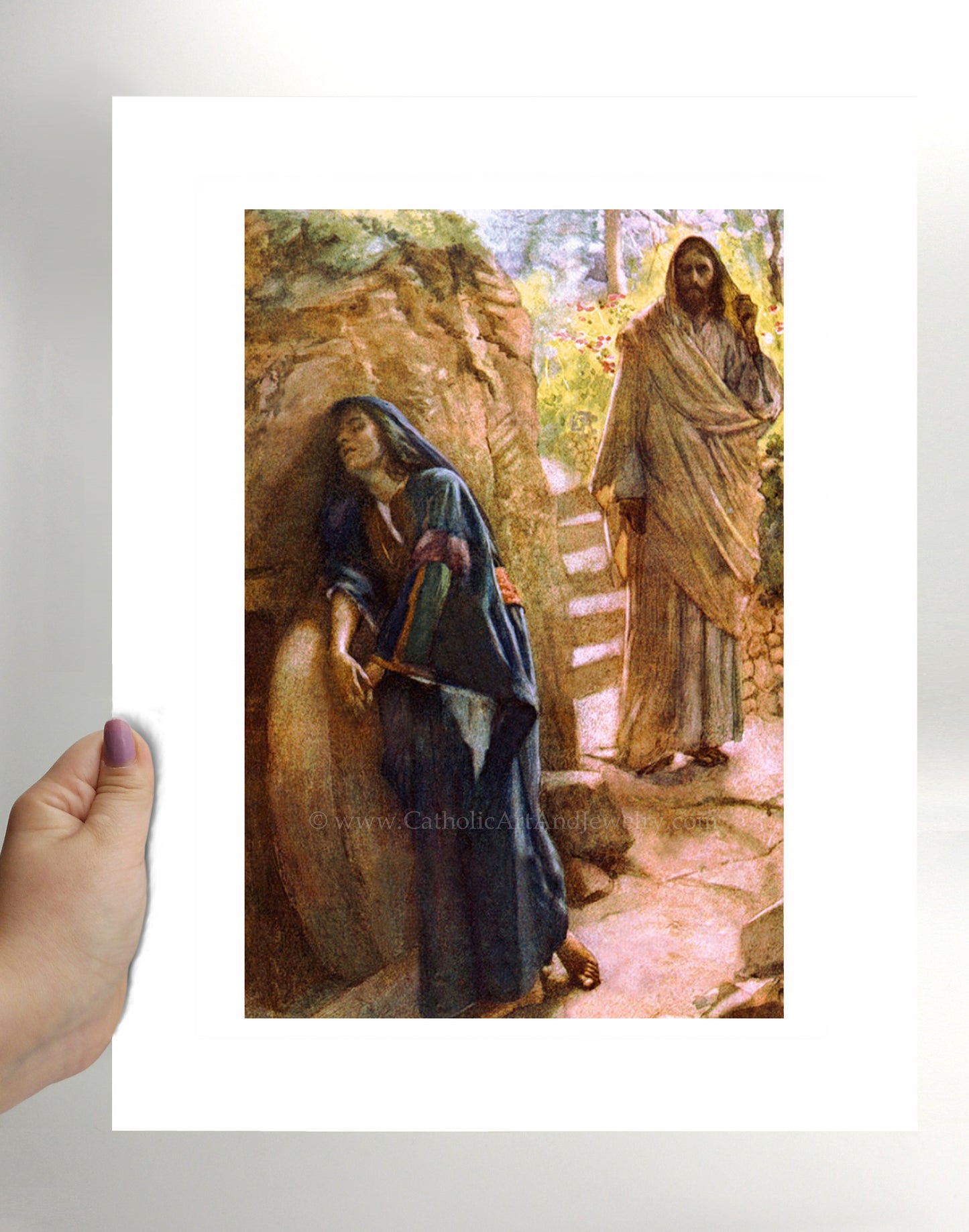 a hand holding a picture of jesus and mary