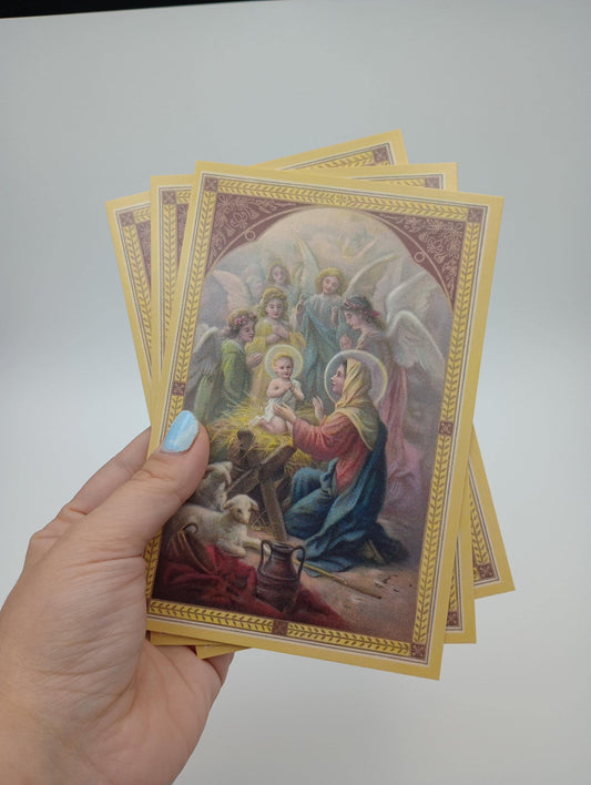 a hand holding a set of four religious cards