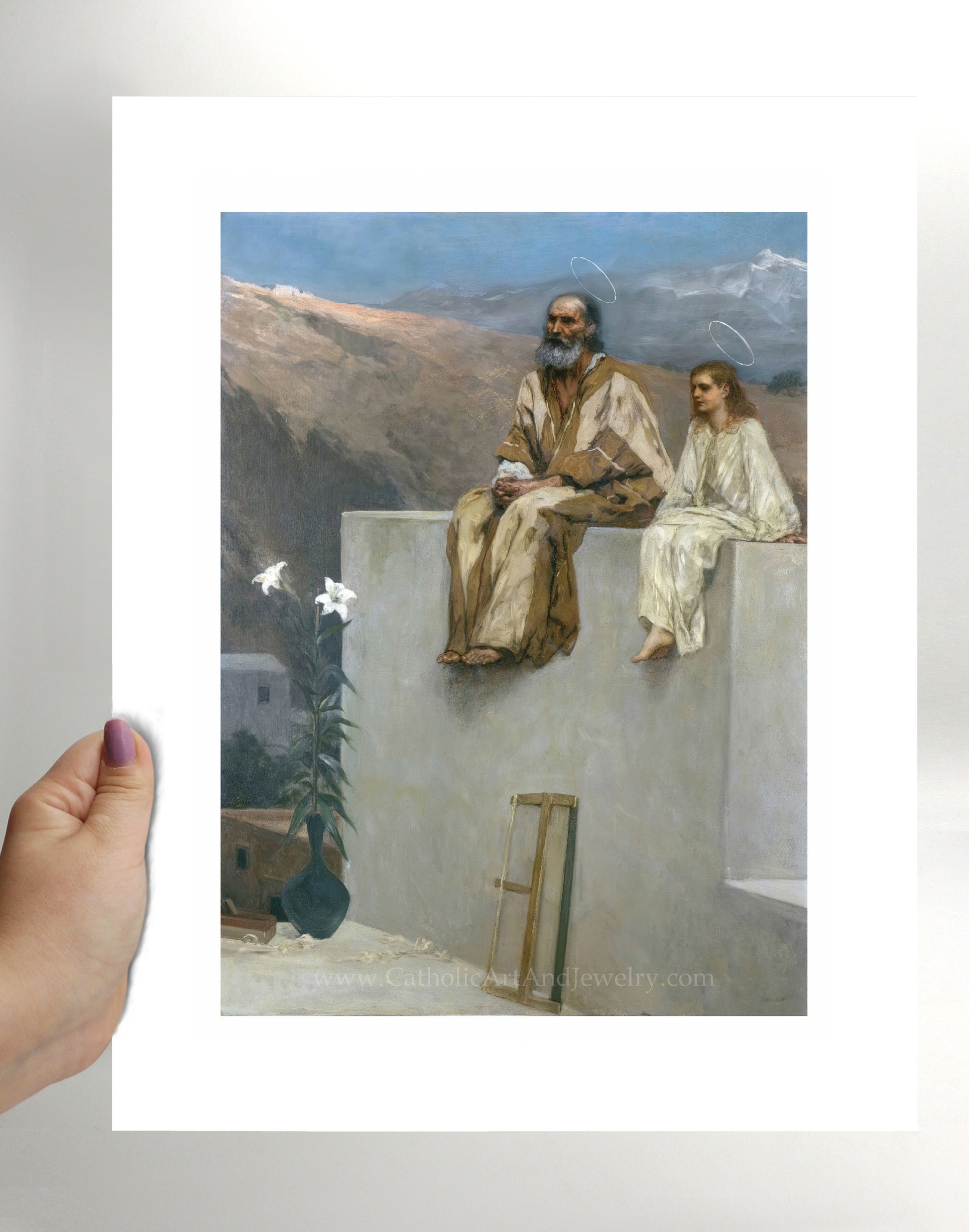 a person holding a picture of jesus and mary